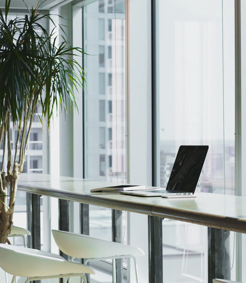 Espacio de trabajo luminoso con un portátil junto a la ventana